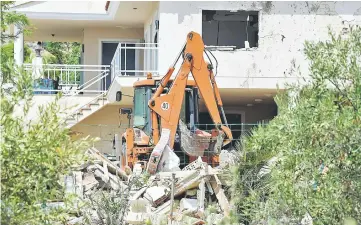  ??  ?? A crane works in the rubble of a house, where suspects of the twin assaults in Spain were believed to be building bombs, in Alcanar. Police said yesterday they had found more than 120 gas canisters in a house in Alcanar, where suspects of the twin...