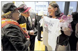  ?? Arkansas Democrat-Gazette/THOMAS METTHE ?? Angela Danovi (right) shows off her Clinton-Gore ’96 campaign T-shirt to Marian and David Hodges during Friday’s gathering at the Butler Center for Arkansas Studies in downtown Little Rock.