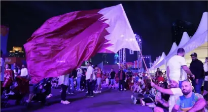  ?? Lee Jin-man/Associated Press ?? A Qatar soccer fan waves as he waits for the World Cup soccer match between Qatar and Ecuador, Nov. 20.