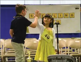  ?? PHOTOS BY CHRIS RILEY — TIMES-HERALD ?? Claire Naing from Loma Vista Elementary high fives Jackson Ady as Niang took second place in the Solano County Spelling Bee. The pair move on to the state bee.