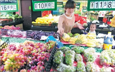  ?? WANG BIAO / FOR CHINA DAILY ?? A customer selects fruits at a supermarke­t in Fuyang, Anhui province.