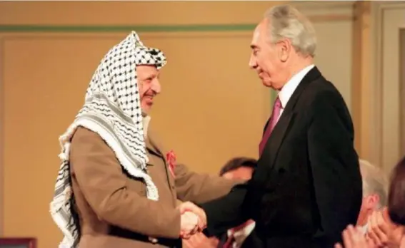  ?? (Getty) ?? PLO chairman Yasser Arafat shakes hands with the then Israeli Foreign Minister in 1994