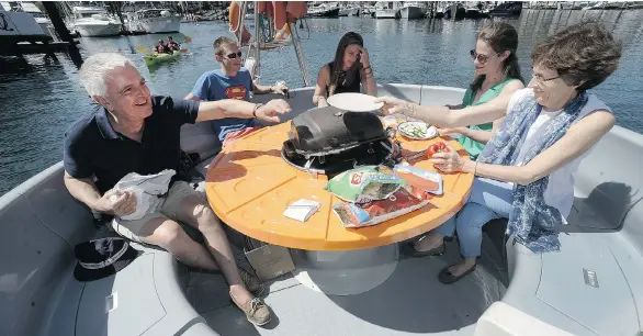  ?? NICK PROCAYLO/PNG ?? The Van Der Wielen family — Bruno, Diego, Coralie, Anne-Laure and Benedicte — prepare a meal on Joe’s BBQ near Granville Island. The barbecue boats launched last summer.