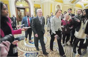  ?? JACQUELYN MARTIN THE ASSOCIATED PRESS ?? Senate Minority Leader Mitch McConnell, centre, walks past members of the media Wednesday after delivering remarks on the Senate floor.