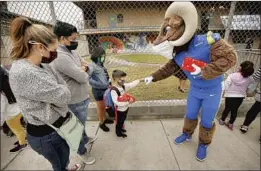  ?? Al Seib Los Angeles Times ?? KINDERGART­ENER Franky Cervantes gets a fist bump from L.A. Rams mascot “Rampage” as he waits with his parents and sister outside Heliotrope.