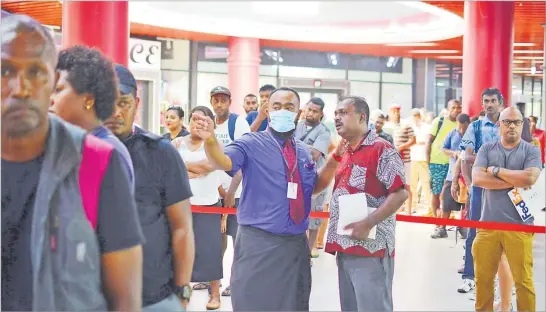  ?? Picture: JOVESA NAISUA ?? FNPF team leader Member Education and Advocacy Matai Daulako advises a customer among the hundreds of people present outside the Suva branch.