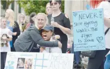  ?? — AFP ?? Supporters of the family of Charlie Gard react after the announceme­nt that his parents have abandoned their legal fight on Monday. (Below) Chris Gard and Connie Yates, the parents of Charlie Gard, arrive at the Royal Courts of Justice in London.