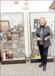  ?? Lynn Atkins/Special to The Weekly Vista ?? Carol Phillips poses in front of a temporary exhibit of her historic fly fishing equipment at the Bella Vista Museum.