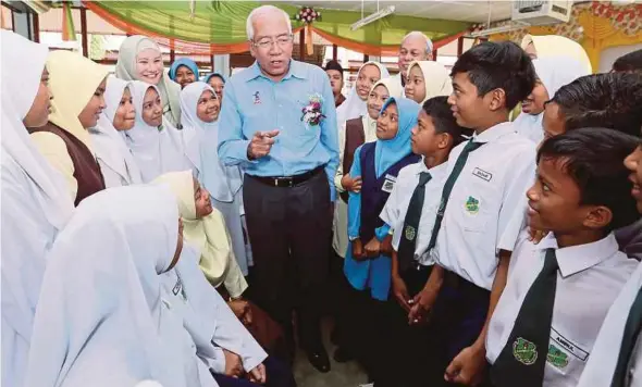  ?? PIC BY AMRAN HAMID ?? Education Minister Datuk Seri Mahdzir Khalid (centre) with Year Six pupils at SK Paya Rawa, Kedah, yesterday.