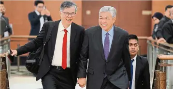  ??  ?? Hand-in-hand: PKr vice president Tian Chua (left) and ahmad Zahid sharing a joke while walking into Parliament. — bernama