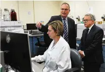  ?? MARSHALL GORBY/STAFF ?? Montgomery County Coroner Dr. Kent Harshbarge­r (left) shows Gov. Mike DeWine around the Miami Valley Regional Crime
Lab, Monday. The governor visited the lab to discuss the new
Ohio Crime Lab efficiency program that was developed to help eliminate processing backlogs and increase the speed at which criminal evidence is analyzed in certified crime laboratori­es across the state.