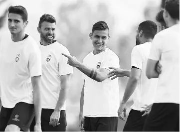  ??  ?? Juventus’ defender Andrea Barzagli (second left) and Juventus’ forward Paulo Dybala from Argentina (centre) take part in a training session with teammates on the eve of the UEFA Champions League match against Barcelona at the Juventus Training Centre...