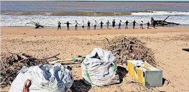  ?? ?? LEARNERS from Green School South Africa, based in Cape Town, clean up at a beach in Durban as part of their Durban Flood Relief Outreach.