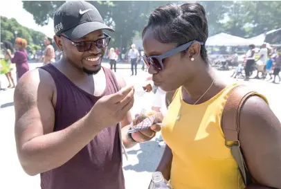  ??  ?? Jamal Chambliss and wife Yesmine try a bite of smoked alligator sausage from Chicago’s Dog House at Taste of Chicago in 2016.