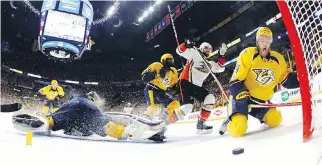  ??  ?? Anaheim Ducks forward Andrew Cogliano, centre right, and Nashville Predators defenceman Mattias Ekholm, right, react to a disallowed goal during the second period of Game 3 on Tuesday in Nashville, Tenn.