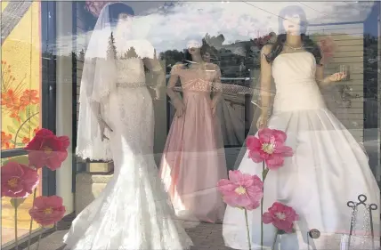  ?? THE ASSOCIATED PRESS ?? Mannequins in wedding gowns are seen in a window display earlier this year at a bridal store in Nogales, Ariz. Couples in the U.S. are racing to the altar in the coronaviru­s vaccinatio­n era.