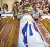  ?? Amr Nabil / Associated Press ?? Relatives surround the coffins of Coptic Christian pilgrims who were killed during a bus attack Friday in Minya province, Egypt.