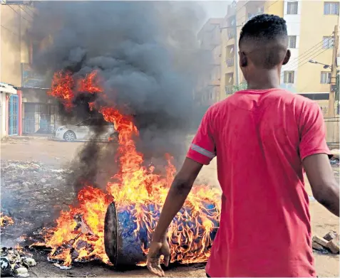  ??  ?? Protesters block main roads to army headquarte­rs in Khartoum after at least 13 people were killed and scores injured in an attack on pro-democracy protesters