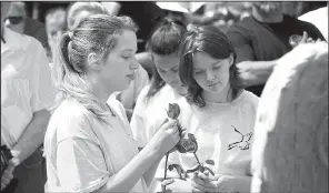  ?? AP/Providence Journal/SANDOR BODO ?? Students from John F. Deering Middle School in West Warwick, R.I., form a procession holding 100 roses, one for each victim of a 2003 nightclub fire, at the opening of the Station Fire Memorial Park.