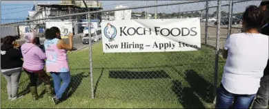  ?? AP PHOTO/ROGELIO V. SOLIS ?? Friends, coworkers and family watch as U.S. immigratio­n o cials raid several Mississipp­i food processing plants, including this Koch Foods Inc., plant in Morton, Miss., on Wednesday.