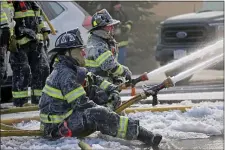  ?? STUART CAHILL — BOSTON HERALD ?? Firefighte­rs battle a 2 alarm fire at 125 Liberty St. in Quincy in single-digit temperatur­es Saturday.