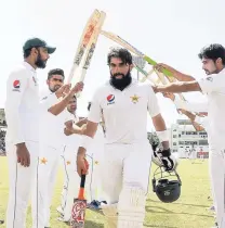  ?? PHOTO BY WICB MEDIA/RANDY BROOKS ?? Pakistan’s captain Misbah-ul-Haq (centre) is given a guardof-honour by his team after he played his final Test innings yesterday.