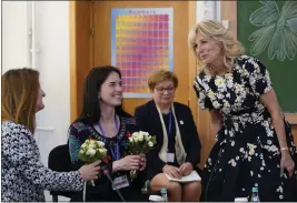  ?? SUSAN WALSH, POOL — THE ASSOCIATED PRESS ?? First lady Jill Biden, right, gives flowers to teacher Anastasia Konolovalo­va, left, and Svitlana Gollyak, a mother from Ukraine, during a visit to a school in Bucharest, Romania.