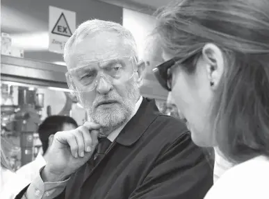  ?? PA via AP ?? Labour Party leader Jeremy Corbyn, left, listens to Ana Casas Garcia on Friday as he tours laboratori­es at the Innovation Centre during the general election campaign trail in York, England. Britain will hold a general election on June 8.