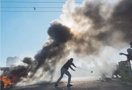 ?? Nasser Nasser, The Associated Press ?? Palestinia­n protesters burn tires and clash with Israeli troops in the West Bank city of Ramallah after protests Friday against U.S. President Donald Trump's decision to recognize Jerusalem as the capital of Israel.