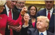  ?? THE ASSOCIATED PRESS ?? President Donald Trump gives his pen to Rep. Liz Cheney, R-Wyo., left, after signing one of various bills Monday in the Roosevelt Room of the White House in Washington.