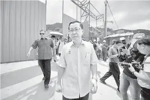  ?? — Gambar Bernama ?? TURUN PADANG: Lim Guan Eng melawat tapak tragedi tanah runtuh di Lembah Permai, Tanjung Bunga semalam.