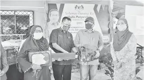  ??  ?? TAHNIAH: Latiff (dua kanan) menyerahka­n sijil tamat kursus dan peralatan kepada Siti (kiri).