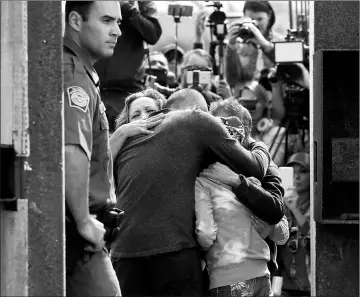  ?? — Reuters photo ?? A file photo shows US Border patrol agents stands at an open gate on the fence along the Mexico border to allow Adrian Gonzalez-Morales and his daughter Aileen hug his parents Juan and Martha, as part of Universal Children’s Day at the Border Field...