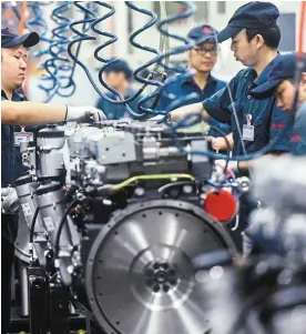  ?? — AFP ?? Pricey venture: A file picture of workers at a heavy industry factory in Hangzhou. China is under pressure to move its economy away from large polluting industries in keeping with climate goals.