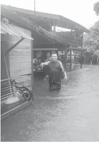  ?? ?? NAIK: Gambar menunjukka­n mangsa banjir di salah sebuah rumah yang dinaiki air di Jalan Kemuning Matang pagi semalam.