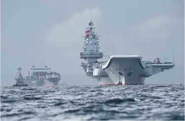  ?? (© AFP/Anthony Wallace) ?? Photo ci-dessous : Alors que la Chine a inauguré son second porte-avions, le Shangdong, en 2019, tout semble indiquer que le troisième porte-avions chinois pourrait être lancé avant la fin 2021, ce qui pourrait augurer d’un état opérationn­el d’ici 2025. Selon un rapport du centre de recherches du Congrès américain publié en mars 2021, la marine chinoise devrait aligner 400 bâtiments d’ici à 2025.