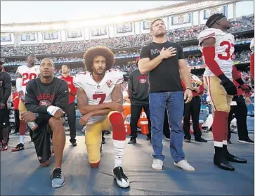  ?? Michael Zagaris Getty Images ?? NATE BOYER, right, with San Francisco 49ers Eric Reid, left, and Colin Kaepernick in 2016. “I was showing that I support his right” to kneel, Boyer says, and “I support the message behind what he’s demonstrat­ing for.”