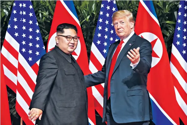  ??  ?? Donald Trump and Kim Jong-un greet one another at their historic summit in Singapore. The US president promised to end war games in South Korea, and the North Korean leader committed to denucleari­sation