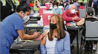  ?? CURTIS COMPTON/CURTIS.COMPTON@AJC.COM ?? Anita Shetty vaccinates Doris Lucas while Dr. Steve Budnick prepares to give Toni Hawkins a shot as operations got underway for Mercedes-benz Stadium to become the largest Community Vaccinatio­n Center in the Southeast, serving 42,000 people a week.