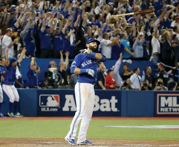  ?? TOM SZCZERBOWS­KI/GETTY IMAGES ?? Jose Bautista tosses his bat in the air after slamming a three-run homer in the seventh on Wednesday. The Jays will face Kansas City in the American League Championsh­ip Series, starting Friday.