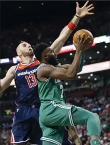  ?? MICHAEL DWYER, THE ASSOCIATED PRESS ?? Celtics’ Jaylen Brown shoots in front of Washington Wizards’ Marcin Gortat (13) in Boston on Monday. Washington won, 111-103.