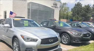  ?? Tom Krisher Associated Press ?? USED INFINITI Q50 luxury sedans await buyers at a dealership in Novi, Mich., a suburb of Detroit. Leases are ending on a large number of Q50s and other cars, f looding the market with quality used vehicles.