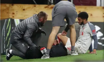  ??  ?? Liverpool’s Joe Gomez receives medical attention after sustaining his injury in the 3-1 win at Burnley. Photograph: Scott Heppell/Reuters