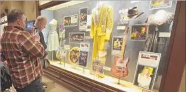  ??  ?? THE RYMAN, clockwise from top, with a guitar and stage shirt donated by Garth Brooks and memorabili­a from other artists on display.