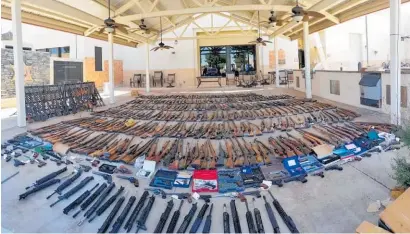  ?? Photos / Los Angeles County Sheriff's Department ?? The gun haul laid out at a local sheriff's station and in the back of a ute.