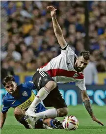  ??  ?? Lucas Pratto é marcado por Emmanuel Mas em jogo contra o Boca pelo Campeonato Argentino