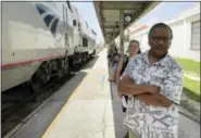  ?? AP PHOTO/MIKE SCHNEIDER ?? Jishnu Mukdrji and Penny Jacobs wait to board an Amtrak train in Orlando, Fla. Murkdrji and Jacobs became friends from online train forums that get other rail enthusiast­s together for trips around the United States. They were headed to Pennsylvan­ia for a memorial service for one of the members in their train group who died of a heart attack in July while traveling with his train buddies.