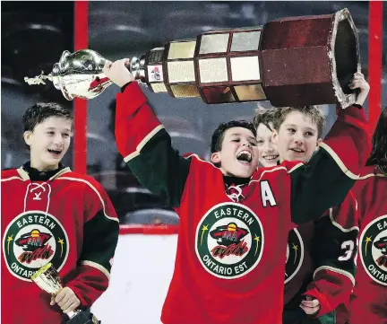  ?? DARREN BROWN. ?? Eastern Ontario’s Ethan Montroy hoists the trophy after the Wild’s victory against the Capitals in the major peewee AAA final at Canadian Tire Centre on Sunday.