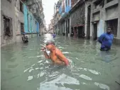  ?? YAMIL LAGE, AFP/GETTY IMAGES ?? Cubans wades through a flooded street in Havana on Sunday after Hurricane Irma passed through.