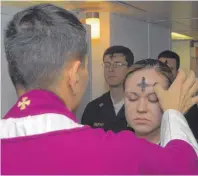  ?? FOTO: MAY ?? Ein katholisch­er Priester zeichnet einem Mädchen ein Aschenkreu­z auf die Stirn.